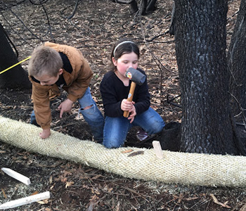 Students work together to stop a hillside from eroding in Paradise, CA after the Camp Fire as part of their Cal Water H2O Project, “Protecting Paradise.”