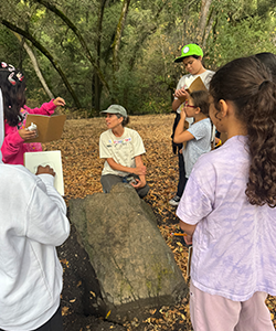 A student shows Chris an interesting plant that she had found. 