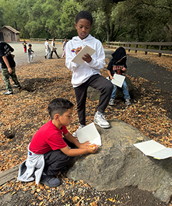 Students nature journaling with their buddies. 