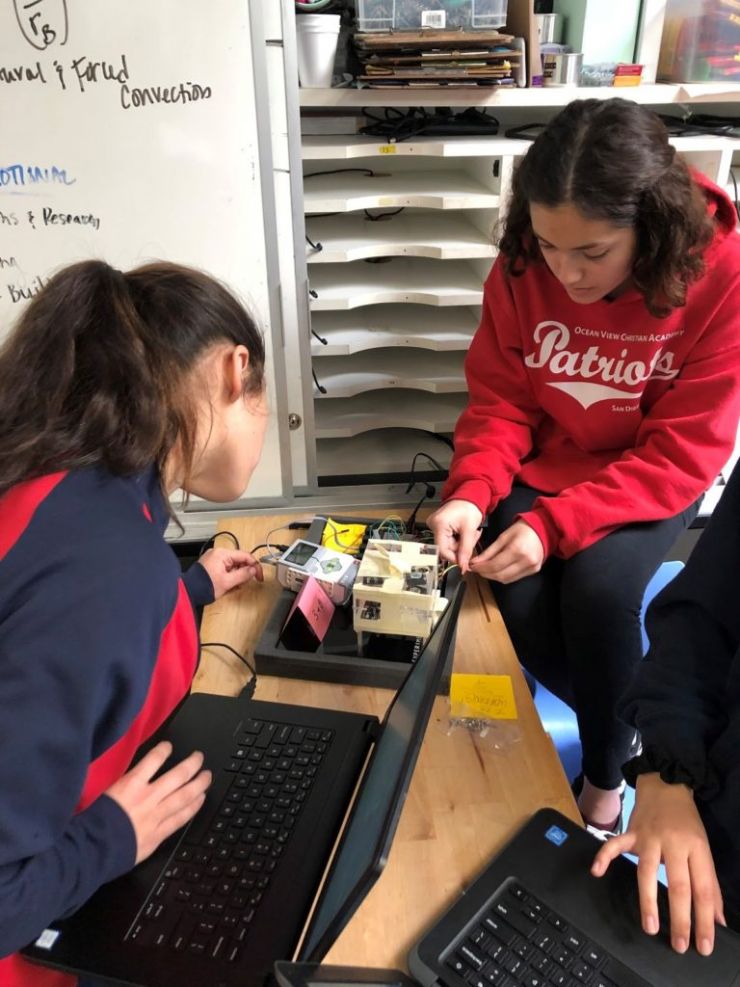 A team testing their code on an experiment cube
